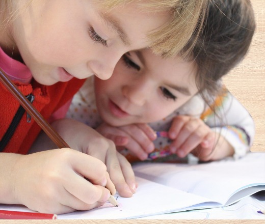 Children working happily in the alphabet workbook
